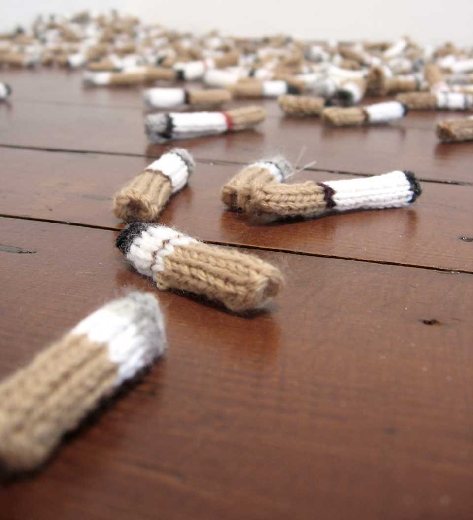  STILL BURNING | 700 hand knitted cigarette butts in wool, cotton, silk (lifesize).