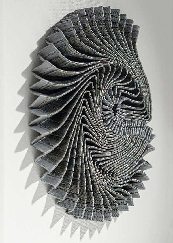 AMMONITE SHADOW: Ardescia Swirl | 2022 | Framed size: 43cm x 43cm x 7cm | Materials and Techniques: Hannah White's woven fabric pleated, sculpted and hand-stitched to stretched canvas in a deep wooden frame with art glass.| Photograph: Beytan Erkmen.