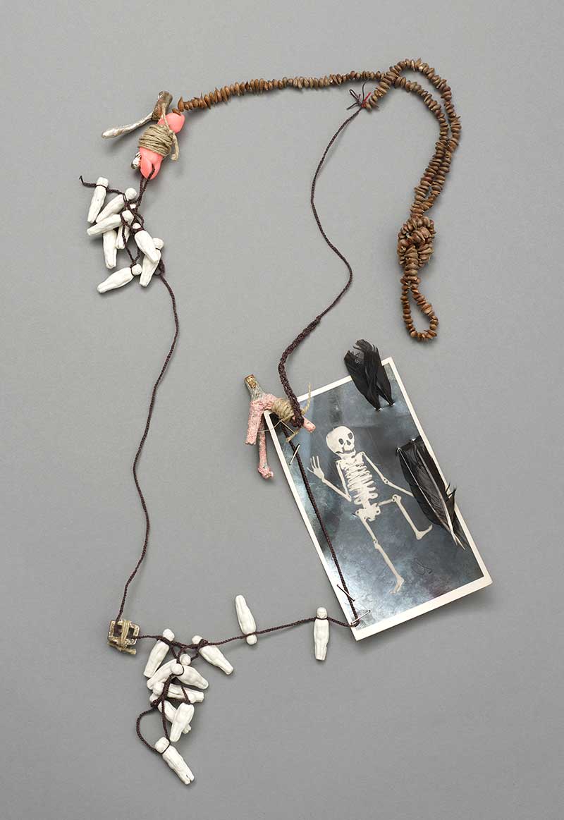 Necklace, from the 13 Treatments collection | Materials: Organic apple seeds, British porcelain, photograph, silver, plastic, waxed thread, rose quartz, pewter, mistletoe, feathers, paint | Techniques:  Cast, hand knit, fabricated, stone set, knotting, magic 2021 |  Image:  Michael Pollard